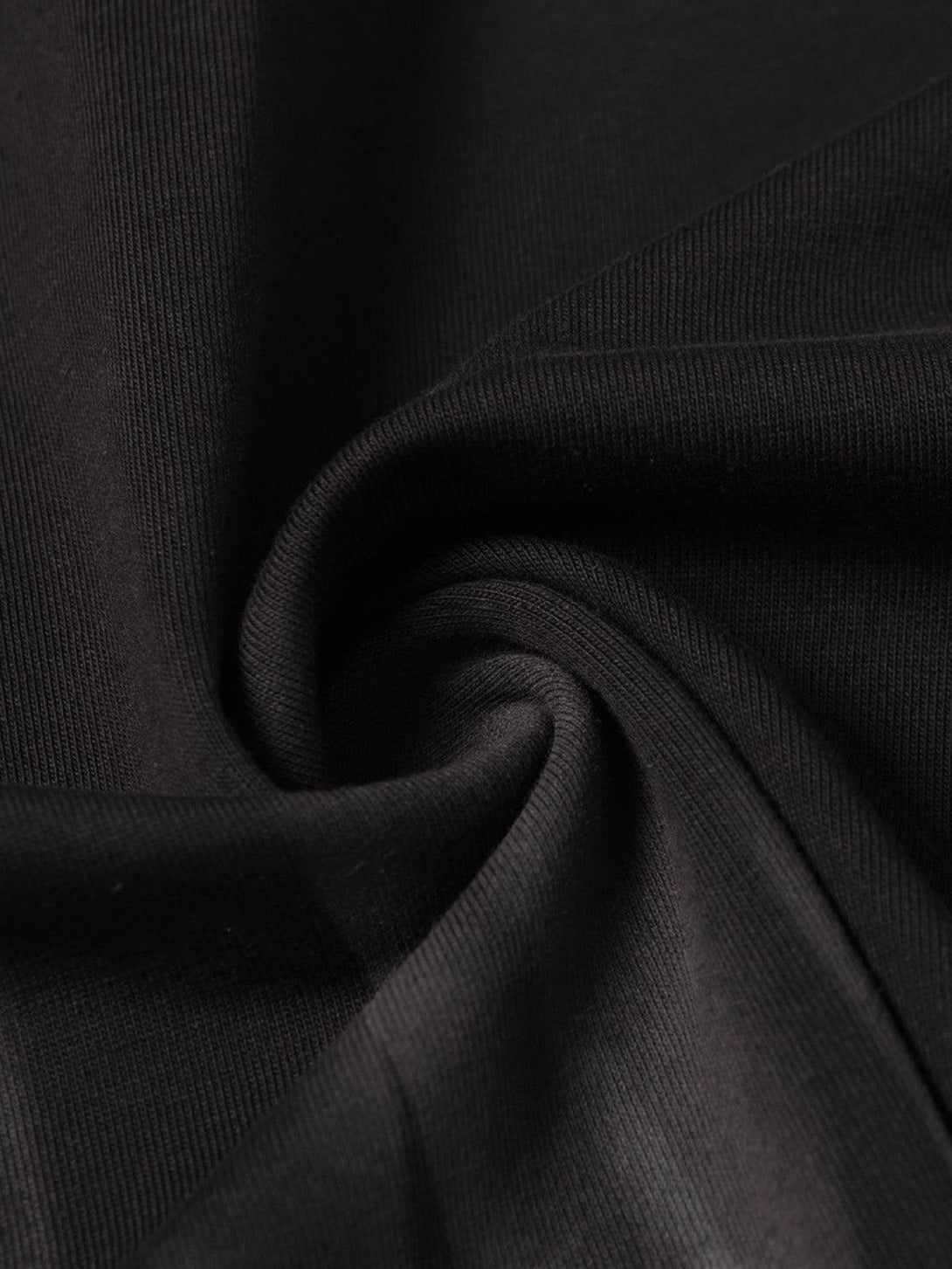 Zoomed-in texture of black fabric from a TALISHKO T-shirt, highlighting quality material.