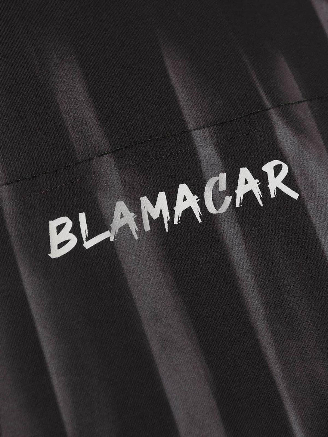 A detailed view of the embroidered lettering on a TALISHKO tie-dye T-shirt, highlighting texture.