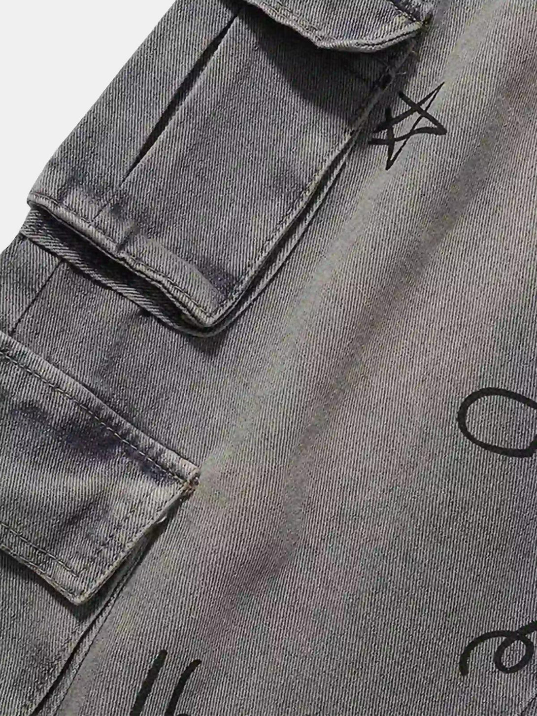 Gray TALISHKO cargo jeans showcasing detailed stitching and artistic designs on pockets.