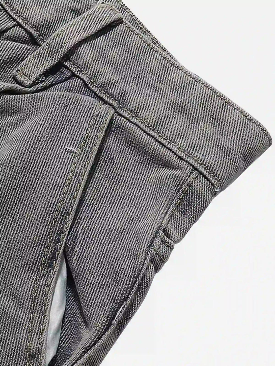 Focusing on the texture and stitching of gray TALISHKO cargo jeans, highlighting pocket details.