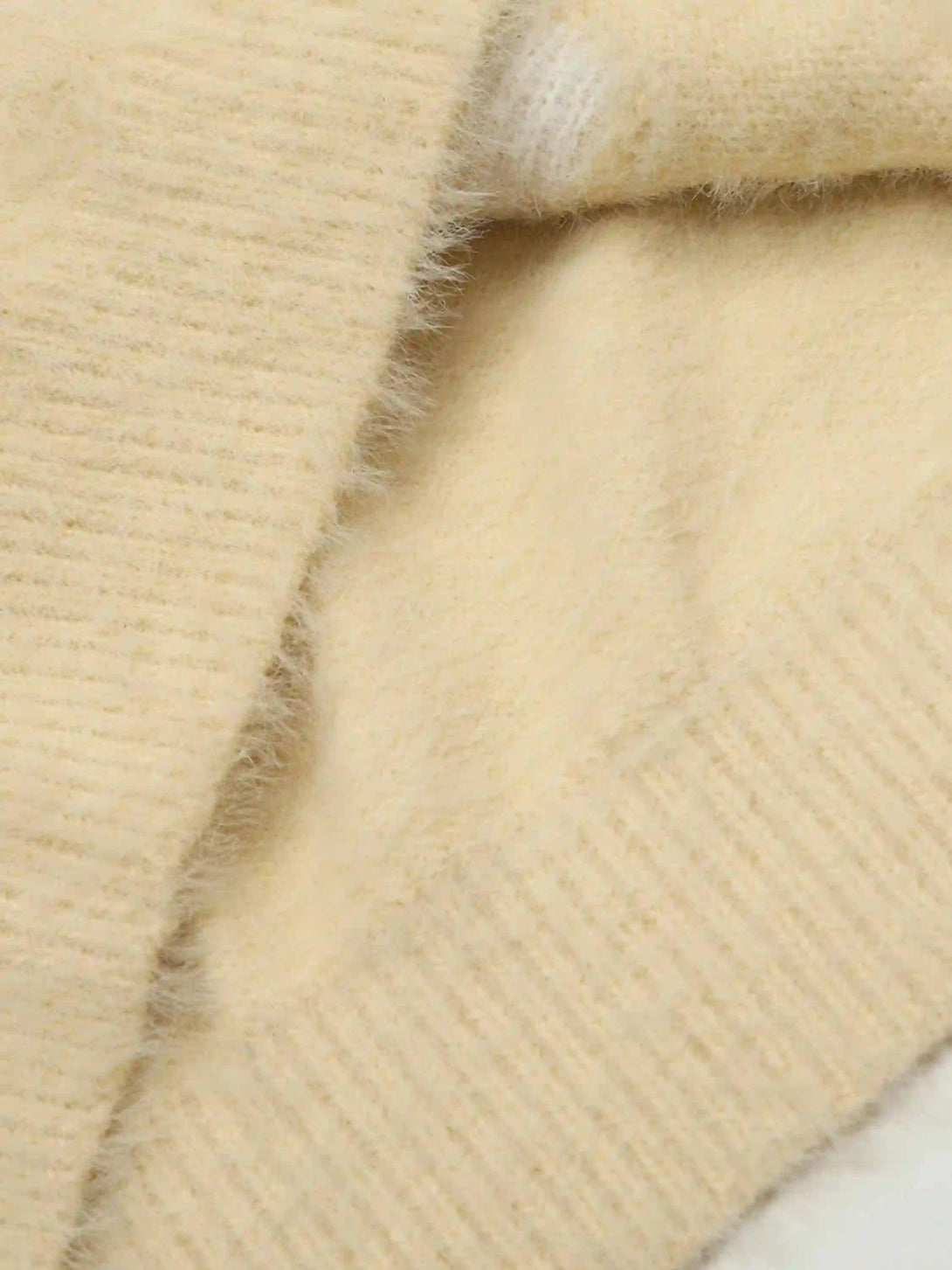 Focusing on the soft texture of TALISHKO's palm graffiti cardigan in a close-up view.