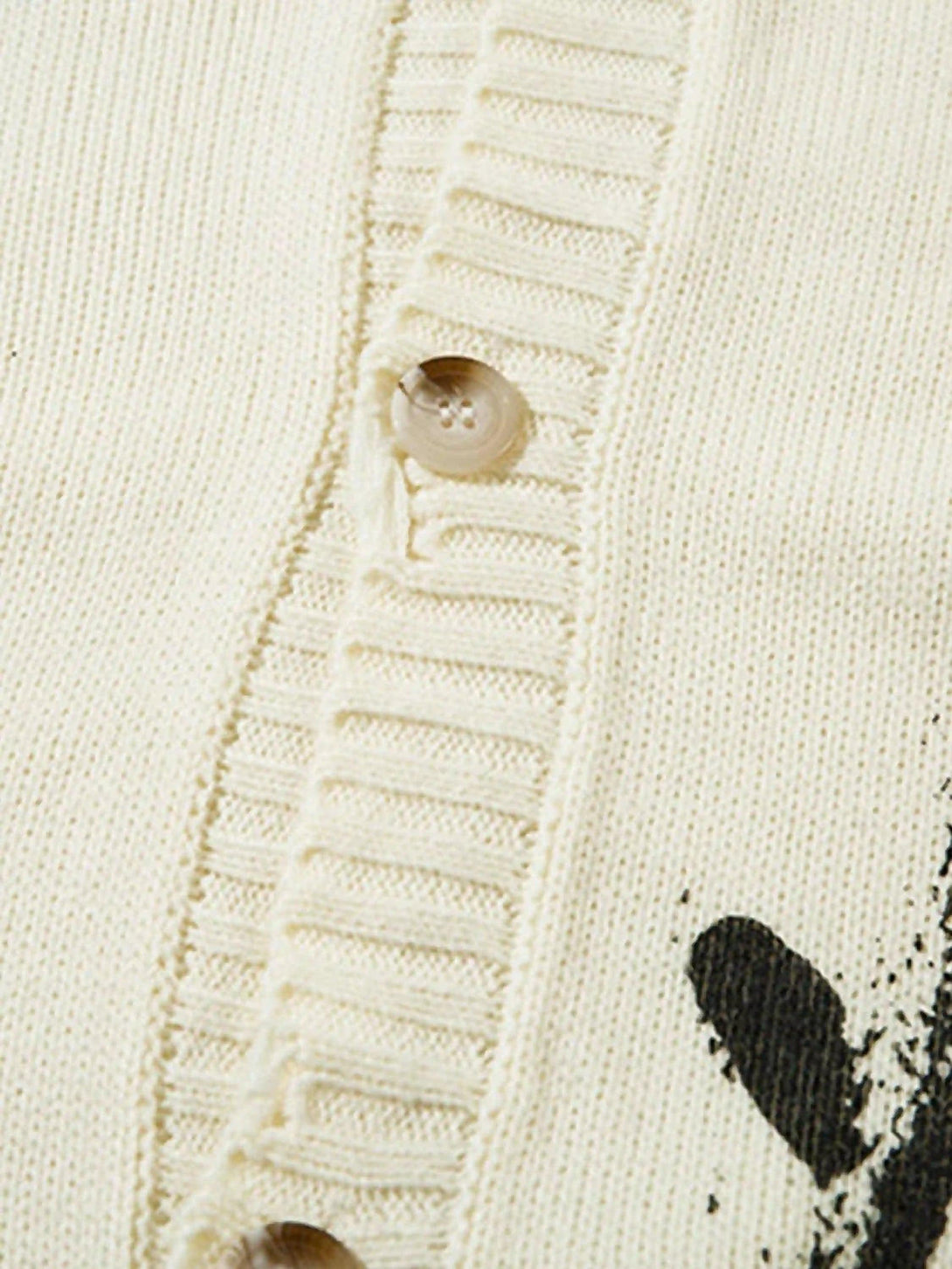 Detailed fabric and button design on TALISHKO's palm graffiti cardigan, highlighting texture.