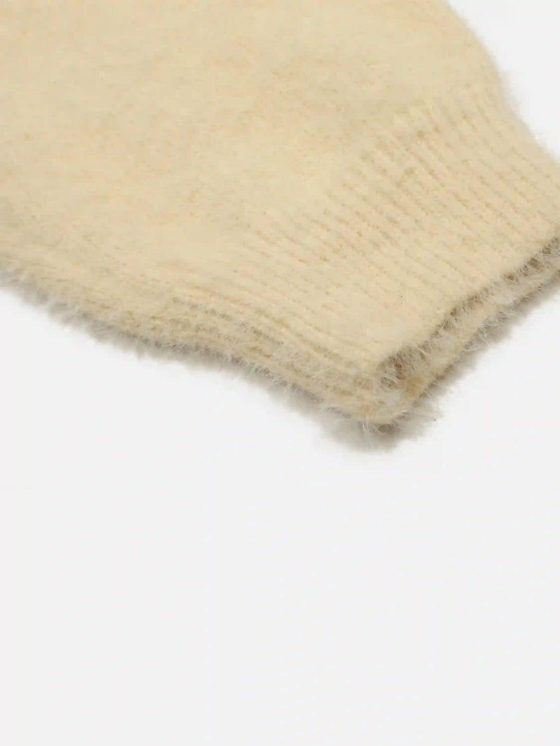 Intricate look at the soft knit texture of TALISHKO's palm graffiti cardigan in beige.