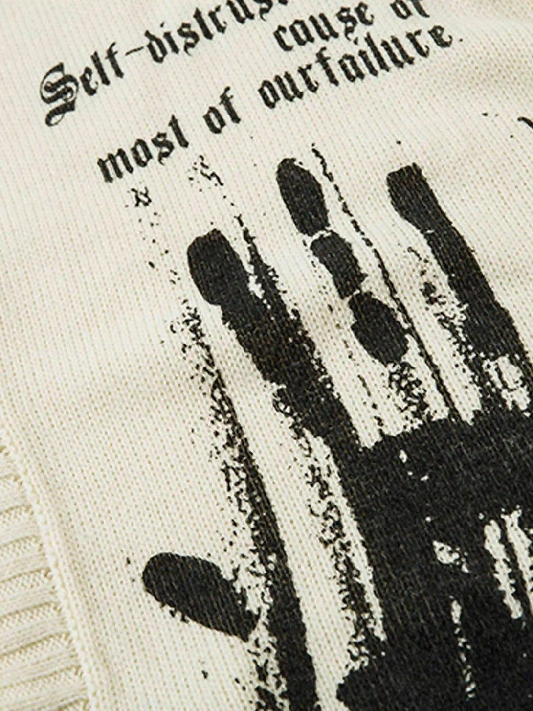 Intricate look at the graffiti handprint design on TALISHKO's palm graffiti cardigan.