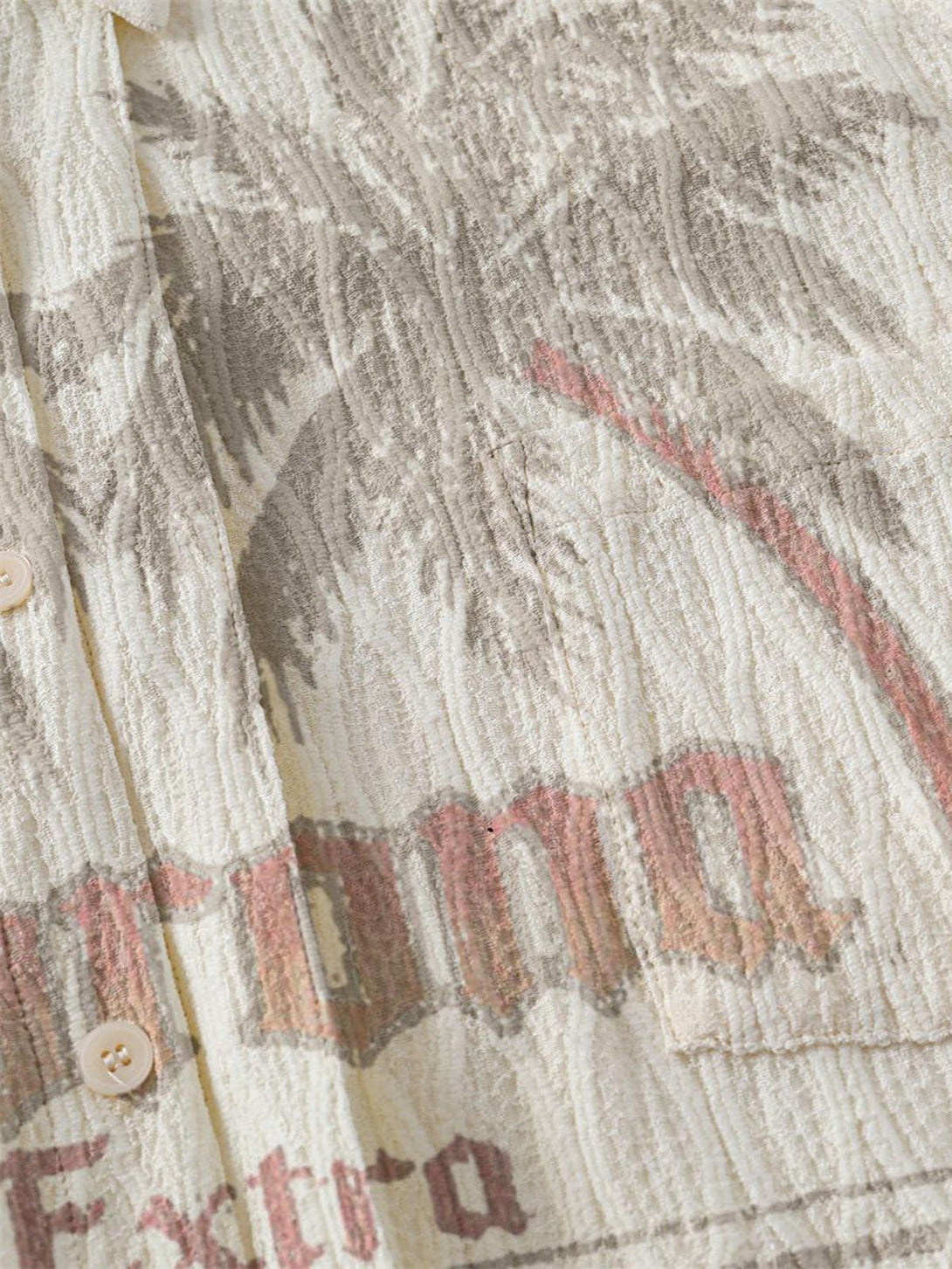 "Intricate look at the textured fabric and palm tree design on a short-sleeve shirt by TALISHKO."