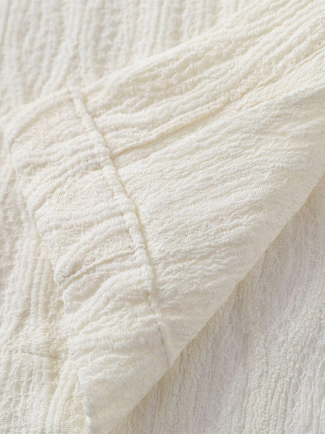 Detailed fabric and texture of TALISHKO palm tree short-sleeve shirt, showcasing intricate design.