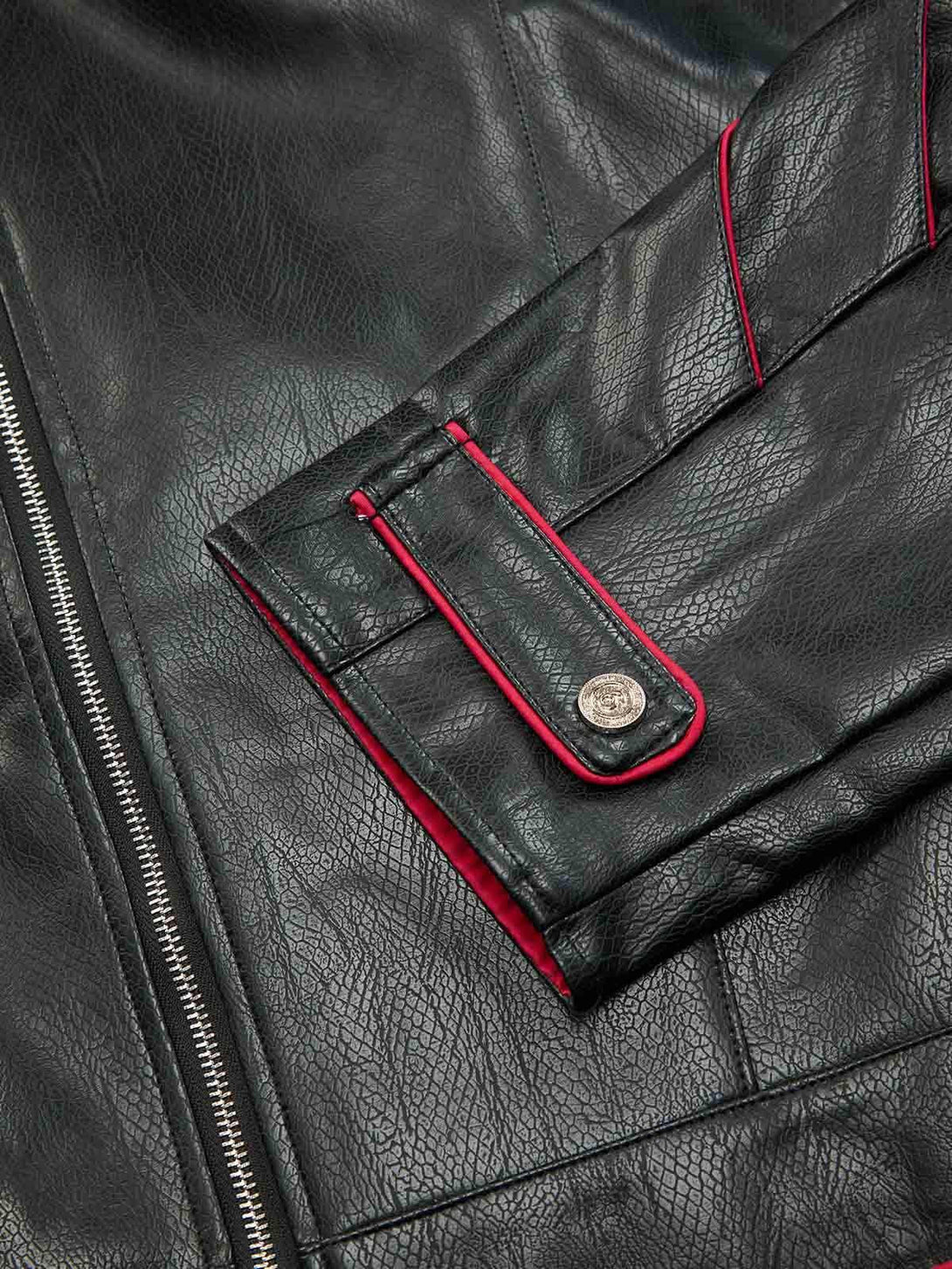 A close-up of TALISHKO leather biker jacket's sleeve, showcasing red accents and textured finish.
