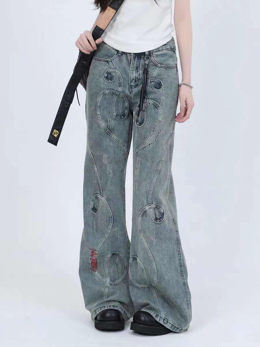 Model in TALISHKO wide-leg jeans with unique swirled stitching, paired with black shoes.