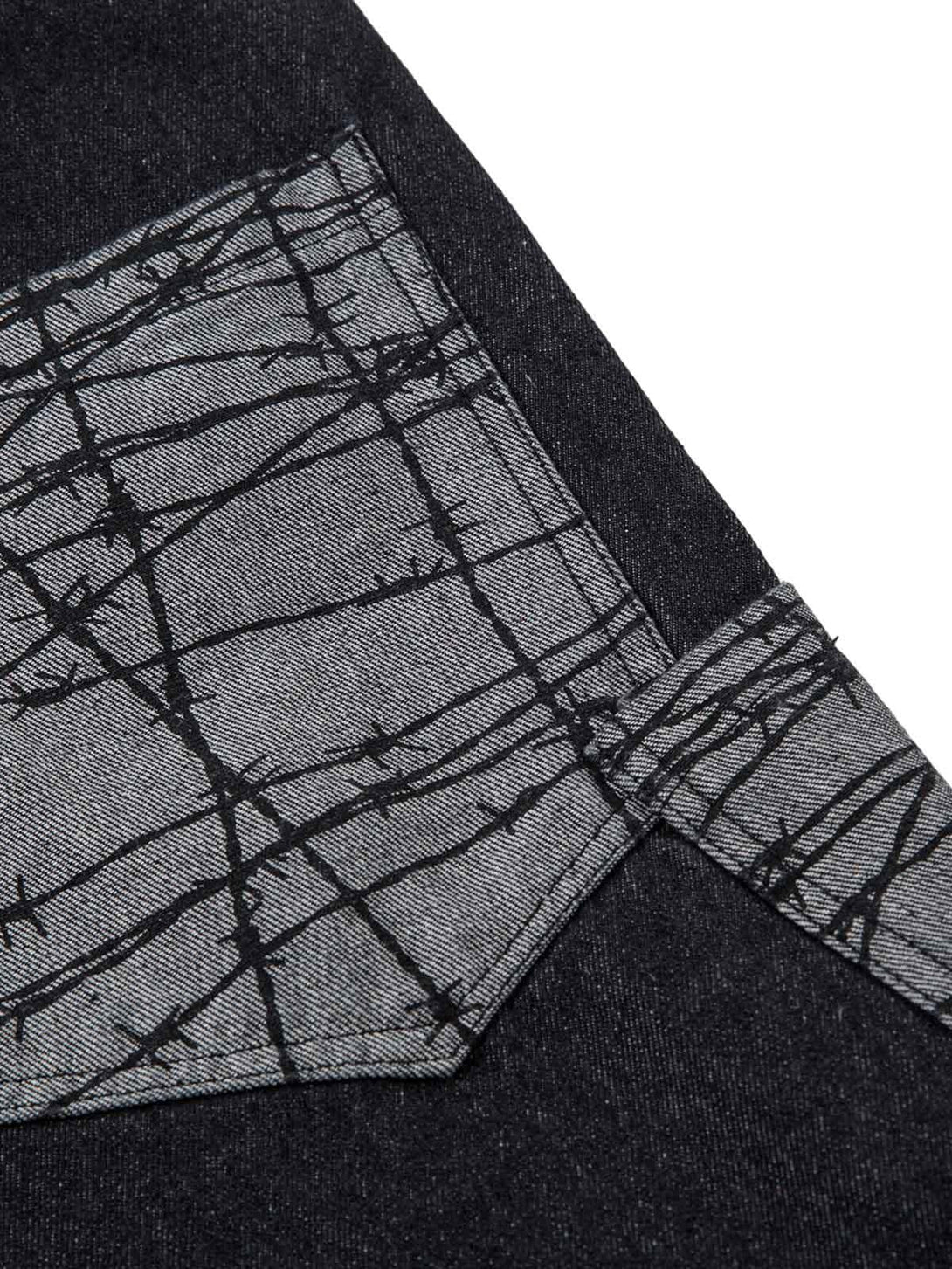 TALISHKO baggy jeans feature a unique patch pocket with intricate barbed wire design detail.