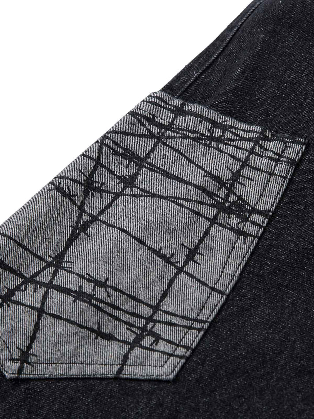 A close-up of TALISHKO baggy jeans' patch pocket, featuring a barbed wire pattern for edgy style.