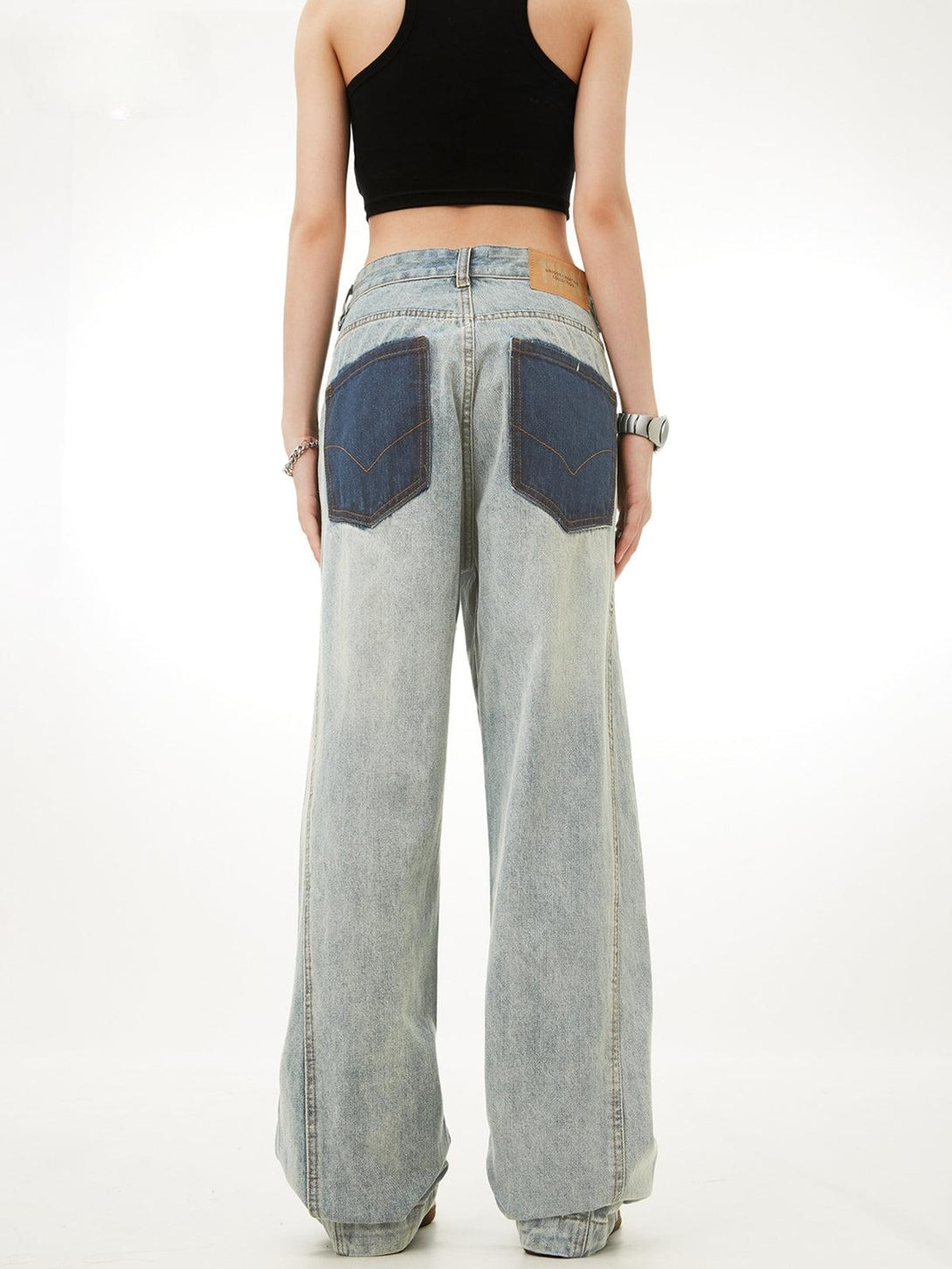 Back view of TALISHKO patchwork color-blocking jeans, emphasizing a relaxed, trendy style.