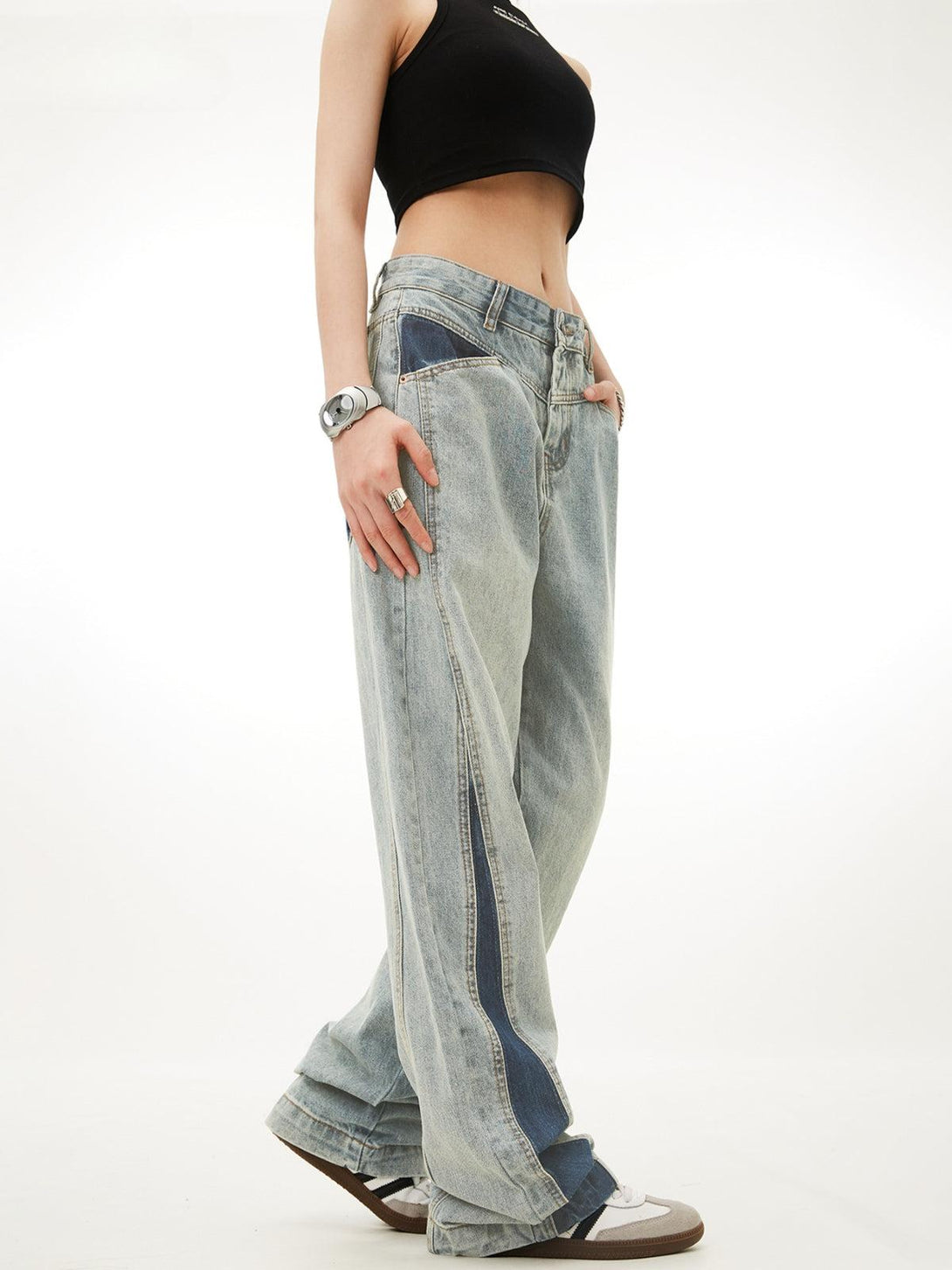 Model in TALISHKO color-blocking jeans shows a relaxed side view, highlighting unique patchwork.