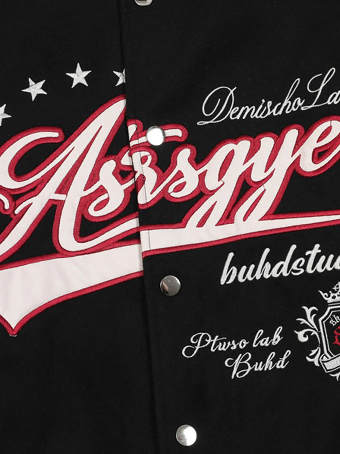 Detailed look at embroidery on TALISHKO's black baseball jacket with contrast patchwork design.
