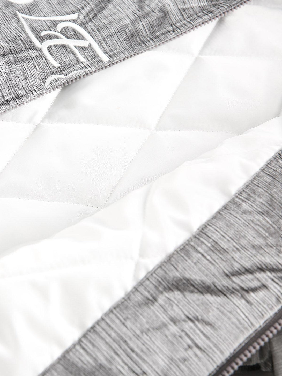 Intricate look at the quilted interior and embroidered detail of a TALISHKO bomber jacket.