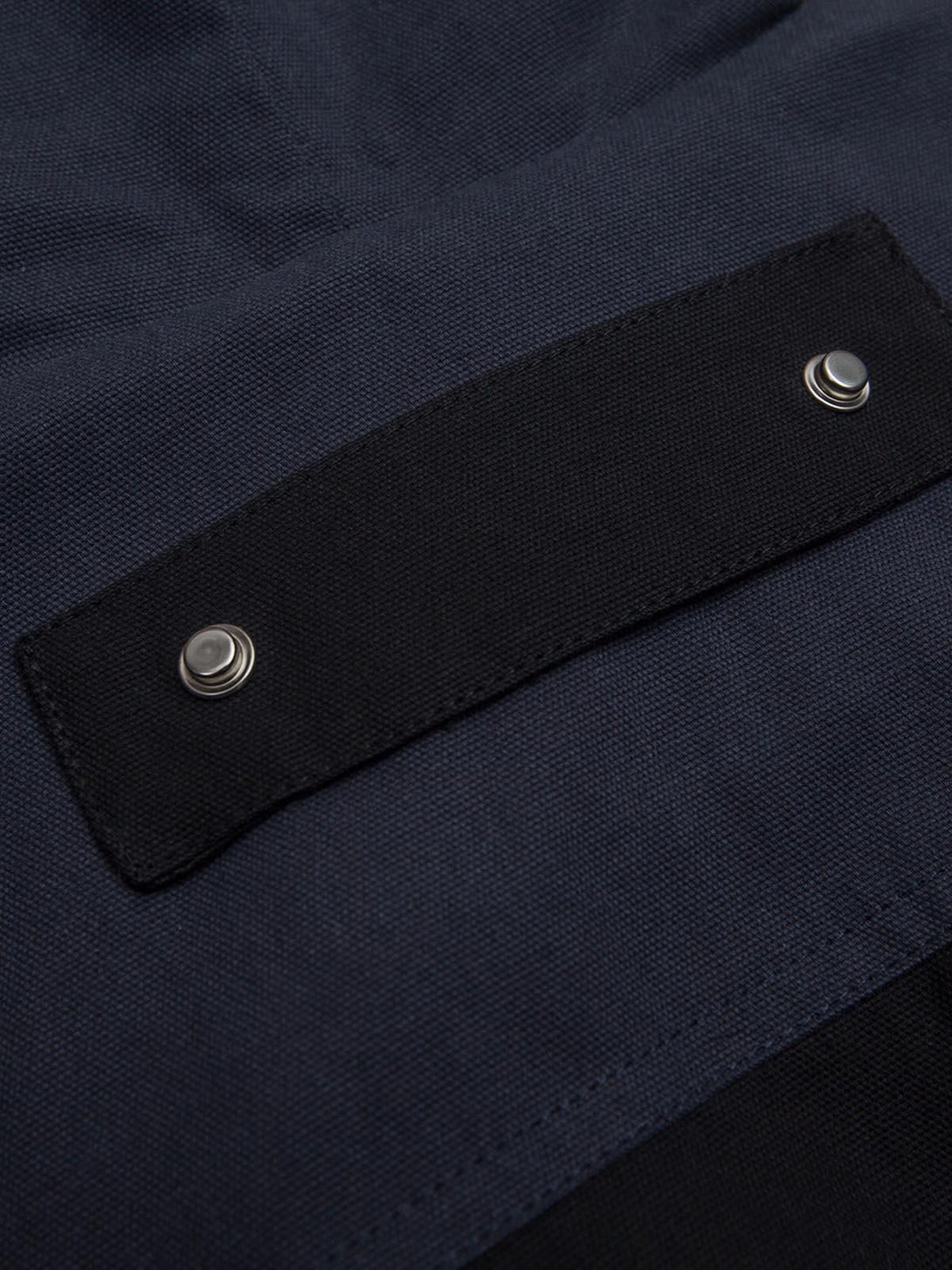 A detailed view of the buttoned flap on a TALISHKO jacket, highlighting craftsmanship and style.