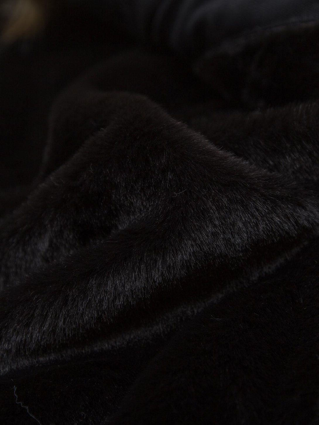 "Zoomed-in texture of the luxurious black fur on a TALISHKO jacket, highlighting its softness."