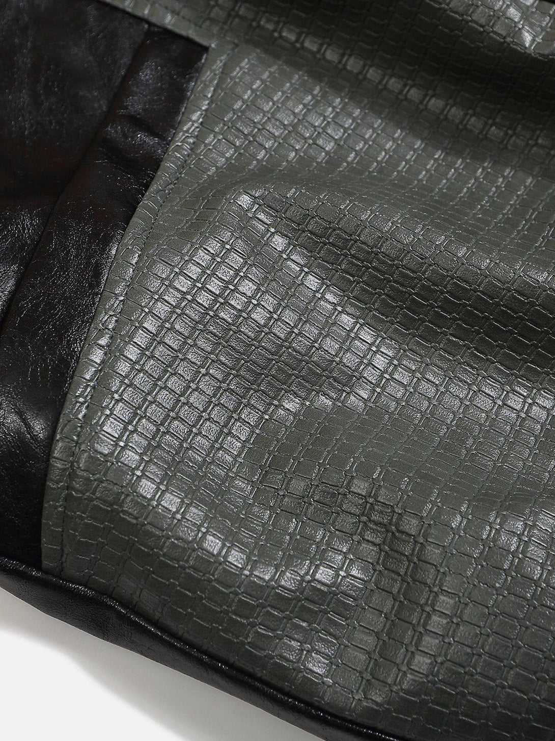 Intricate look at the patchwork texture of a TALISHKO faux leather jacket in black and gray.