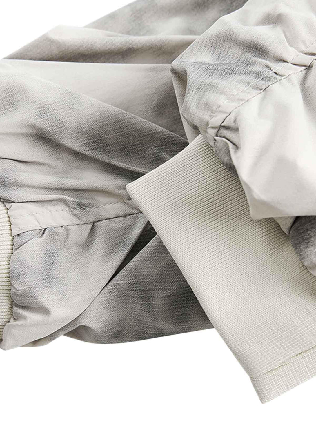 Focusing on the TALISHKO bomber jacket's fabric and cuff details with a gradient effect.
