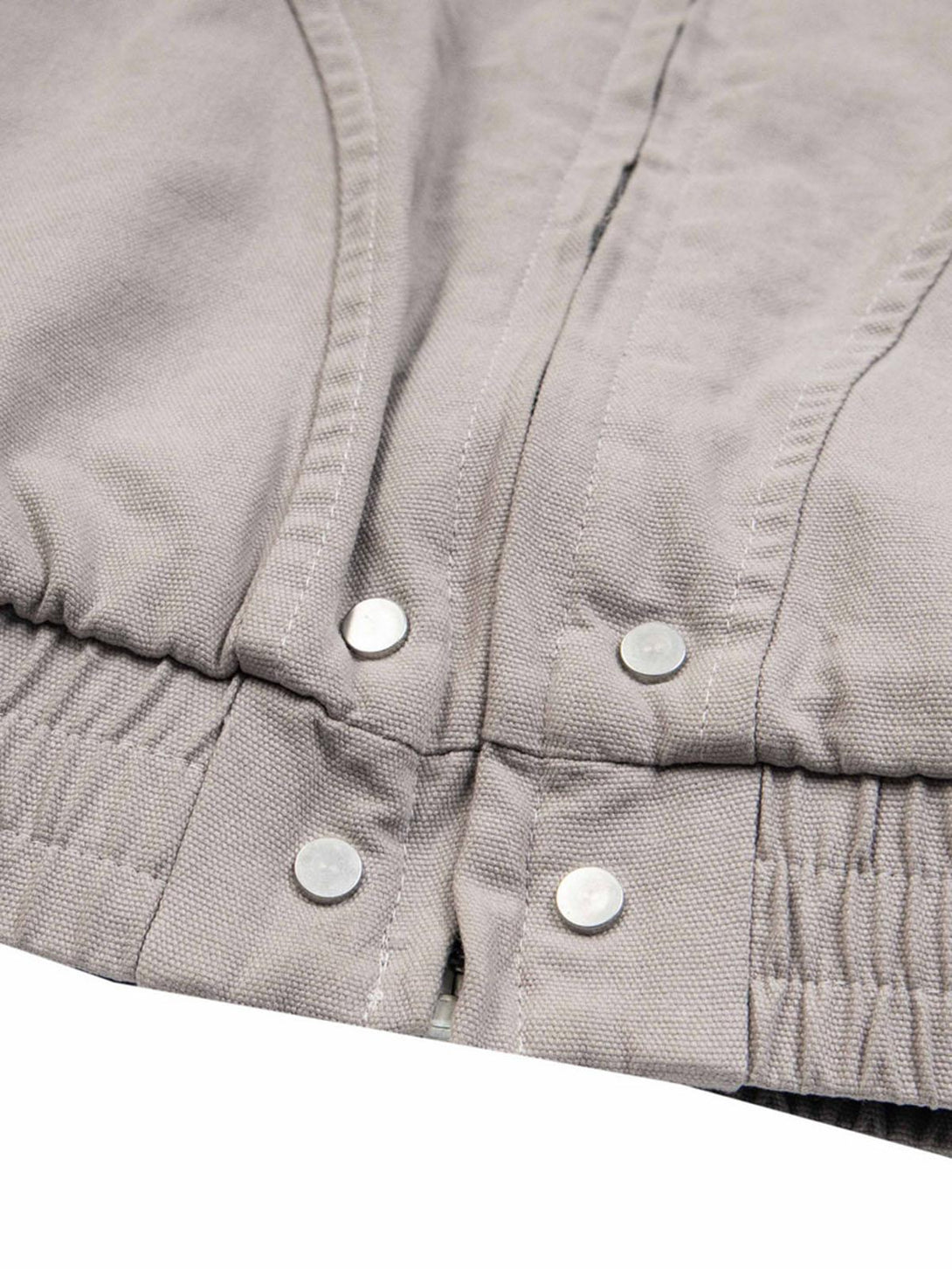 Focusing on the button detail of TALISHKO's quilted jacket, showcasing craftsmanship.