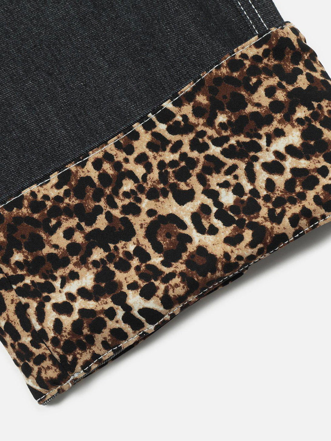 A close-up of TALISHKO jeans with leopard print cuffs, highlighting bold pattern details.