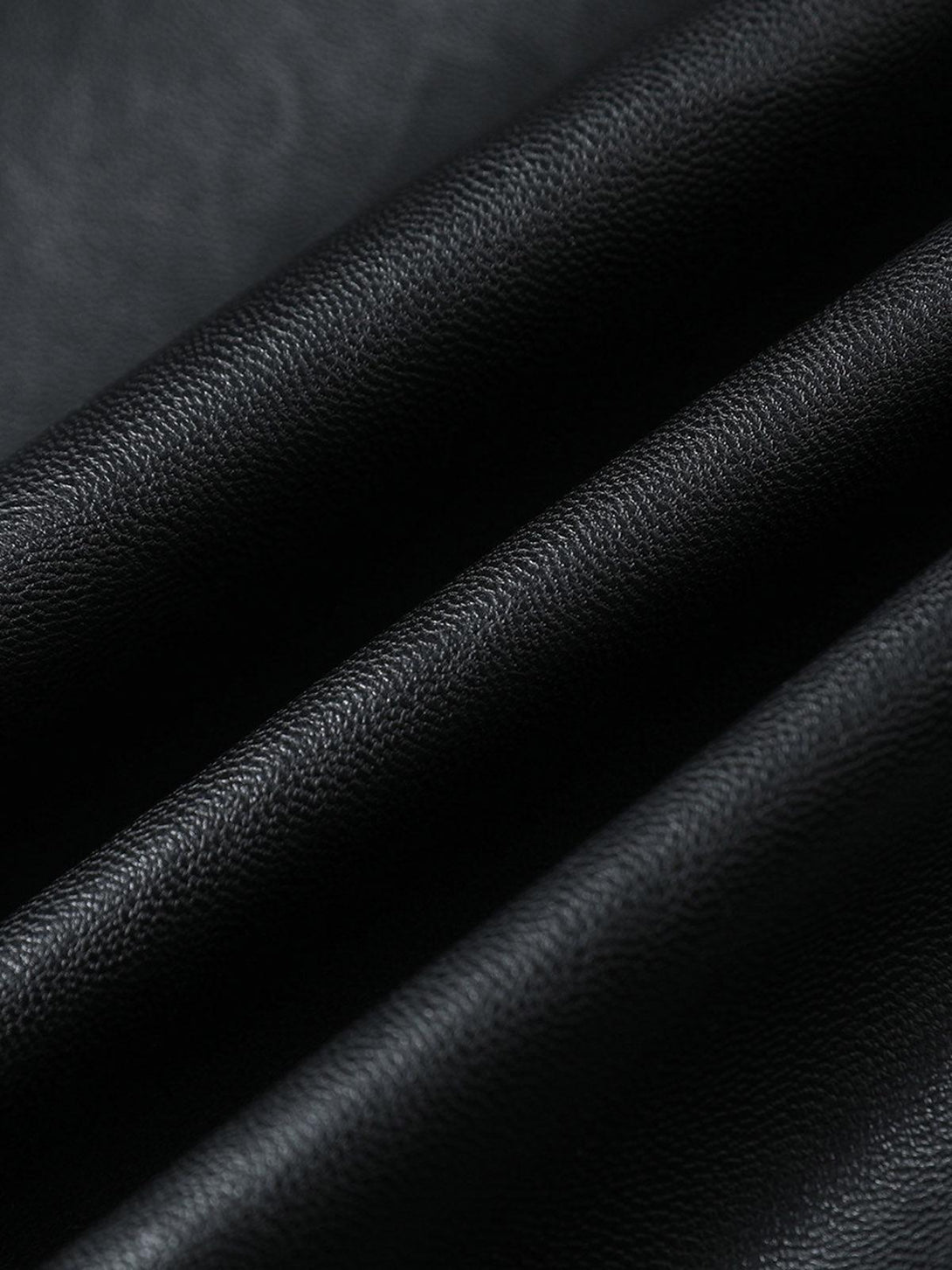 Zoomed-in texture of TALISHKO's PU leather motorcycle jacket, highlighting its fine grain.