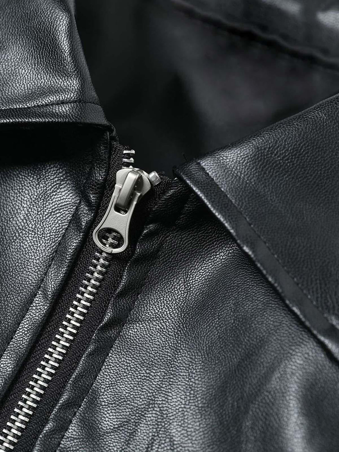 A close-up of TALISHKO's motorcycle jacket zipper and collar, highlighting the leather texture.