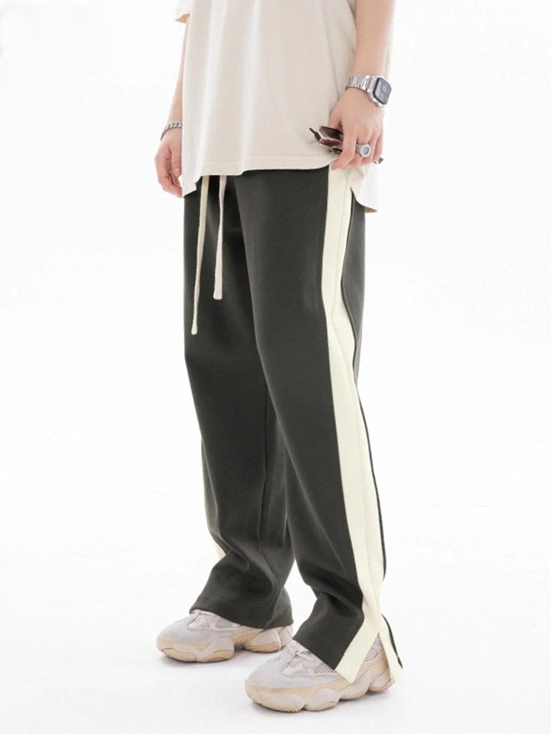 Model wearing TALISHKO patchwork split pants with contrasting side stripes and comfortable fit.
