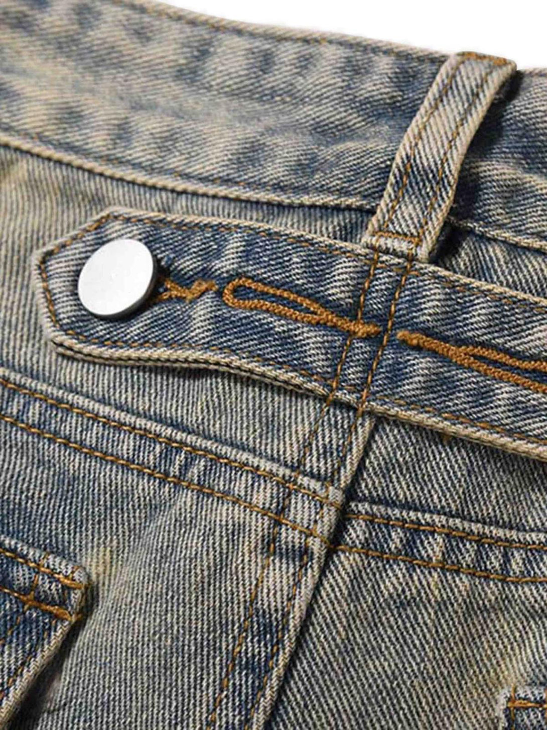 Intricate look at TALISHKO patchwork jeans, focusing on button detail and distressed stitching.