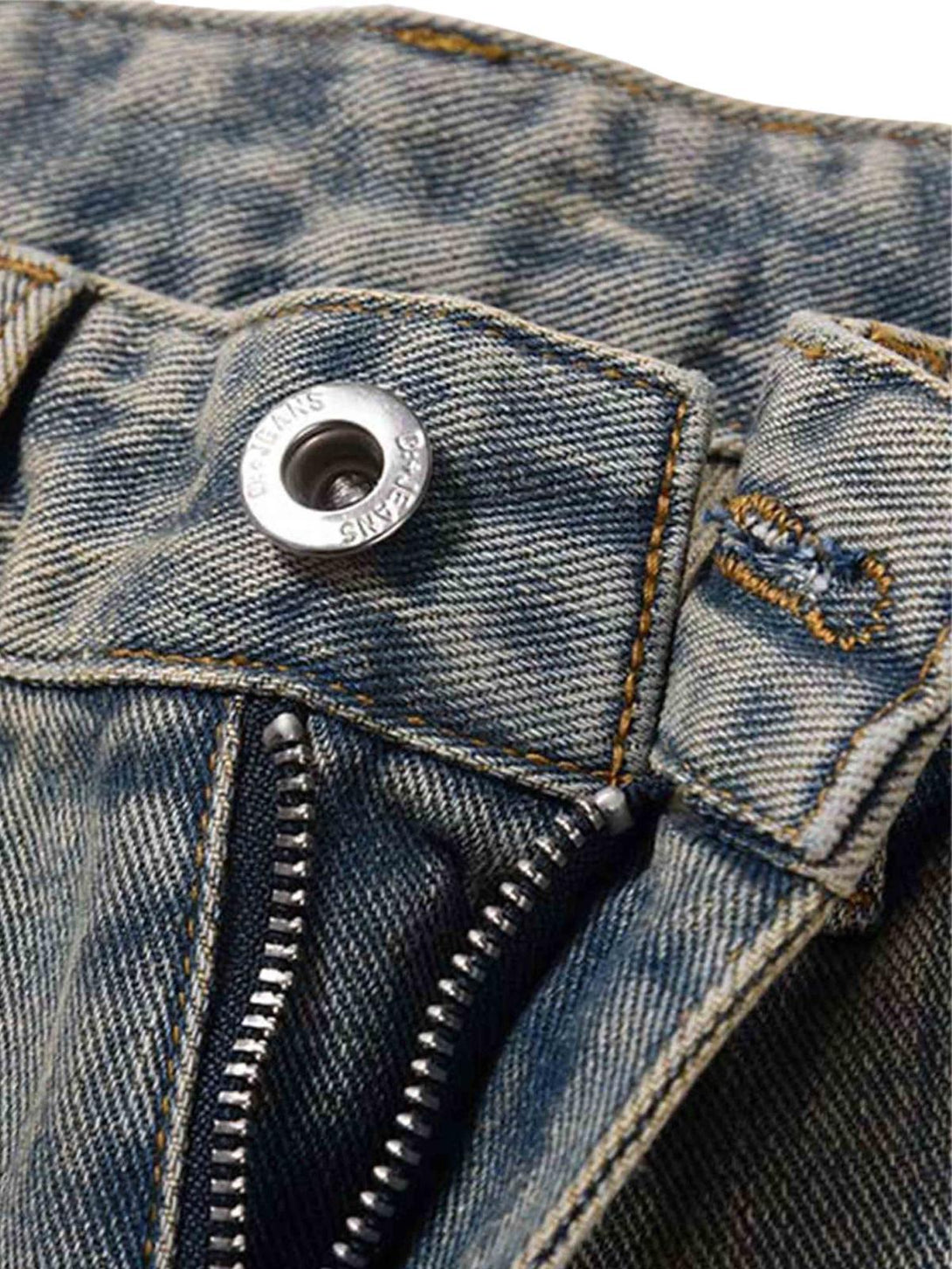 Intricate look at TALISHKO patchwork jeans, highlighting distressed fabric and zipper detail.