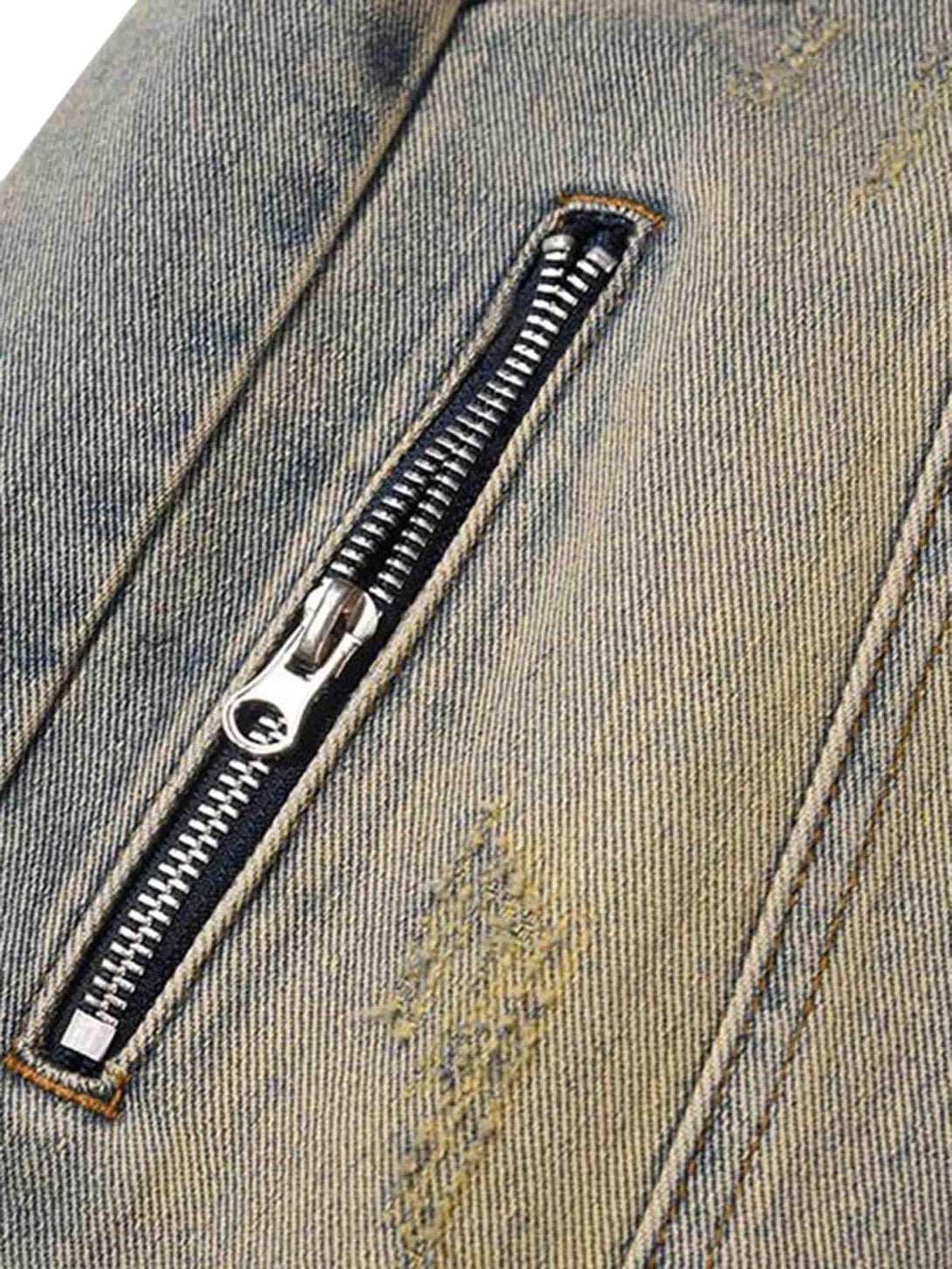 Focusing on the zipper detail of TALISHKO patchwork jeans, showcasing distressed fabric texture.