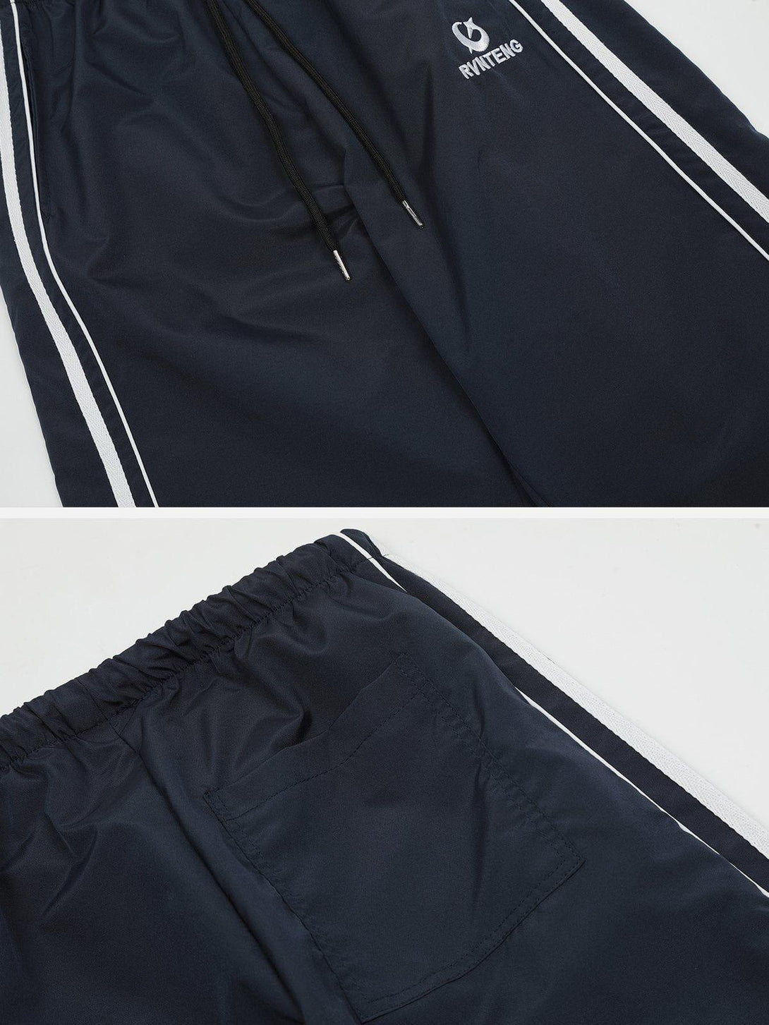 Detailed view of TALISHKO's blue sweatpants, highlighting sporty white side stripes and drawstring.