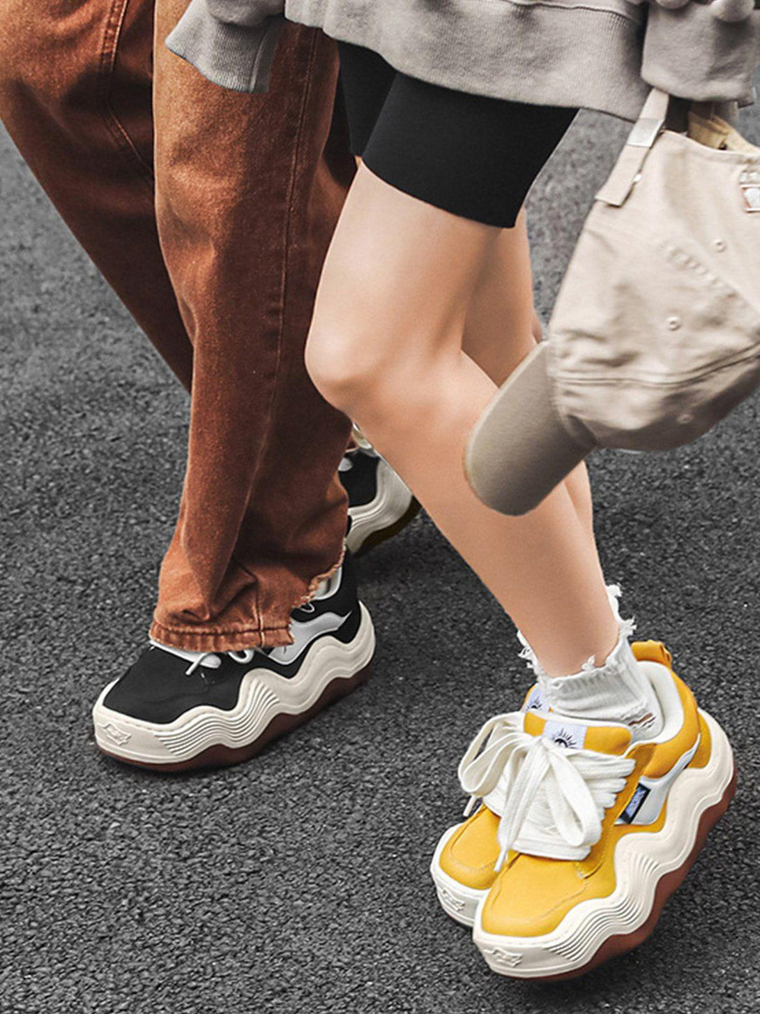 TALISHKO sneakers with thick wavy soles in black and yellow, styled for street fashion.
