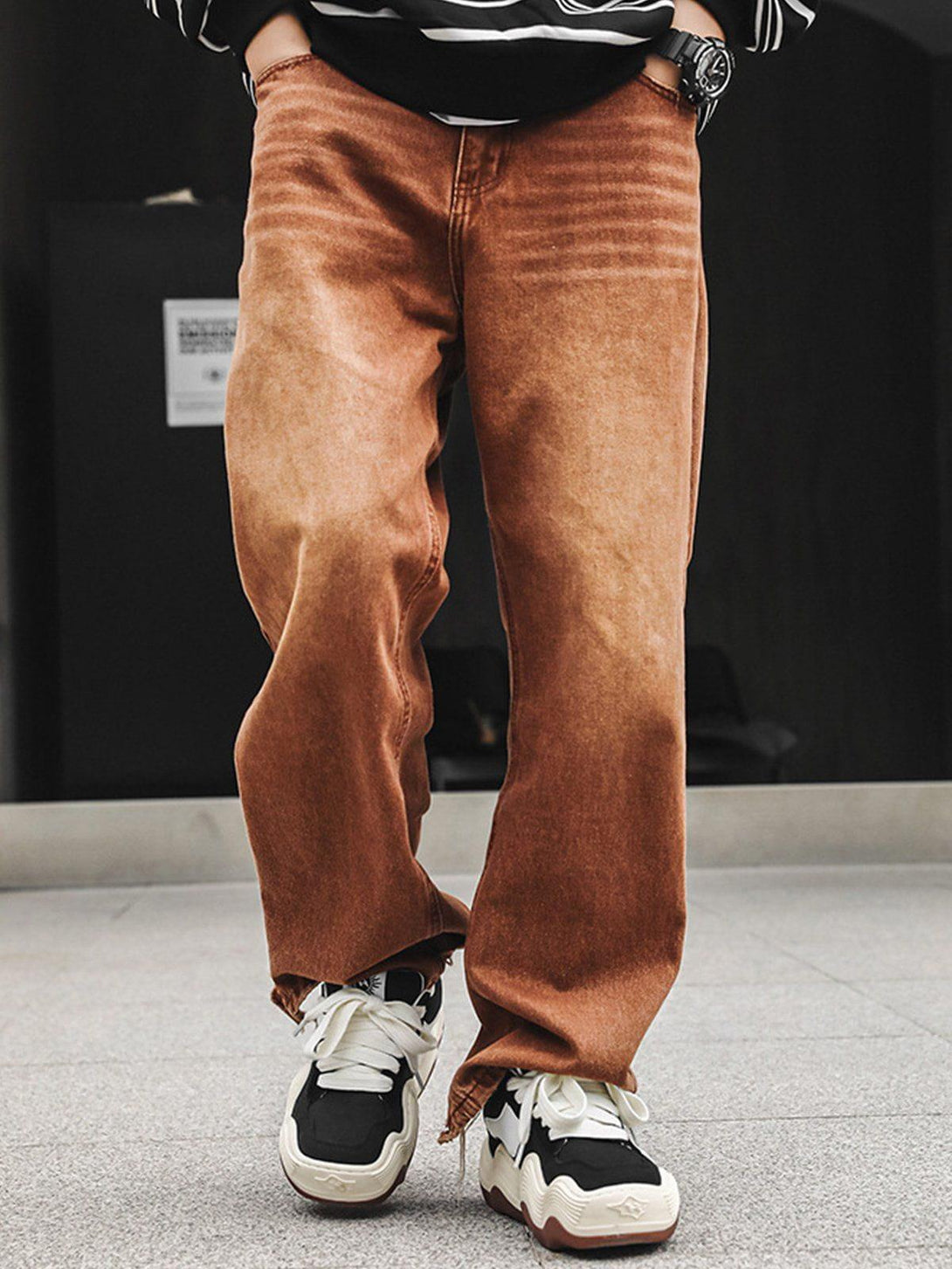 TALISHKO brown jeans paired with thick-soled sneakers, showcasing a relaxed street style.