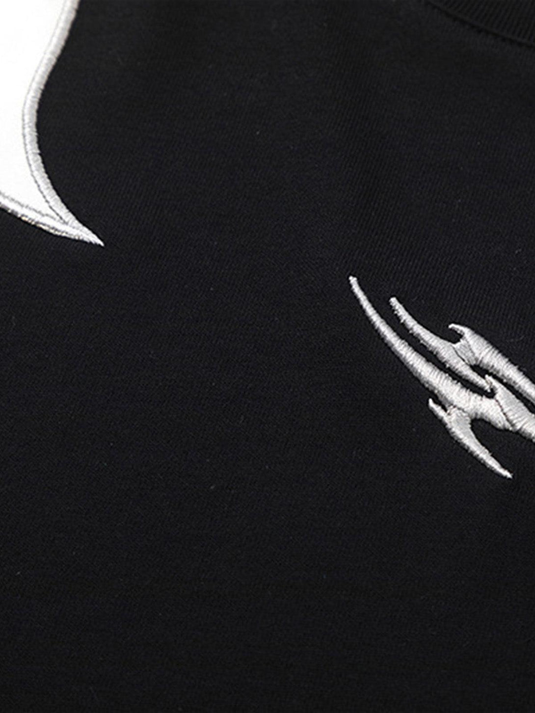 Intricate look at the Patchwork Totem T-shirt by TALISHKO, highlighting detailed embroidery.