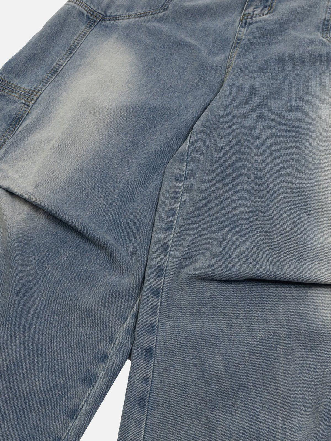 Intricate look at TALISHKO's patchwork waist design on loose jeans, highlighting unique texture.