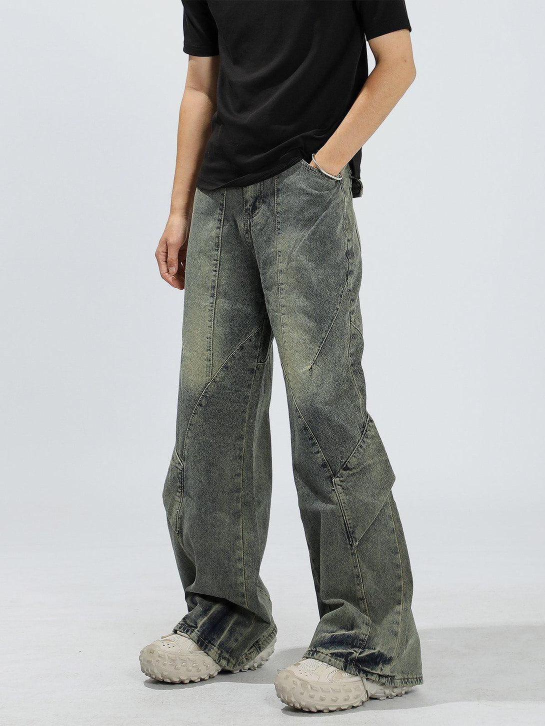 Model wearing patchwork washed jeans by TALISHKO, showcasing relaxed fit and unique detailing.