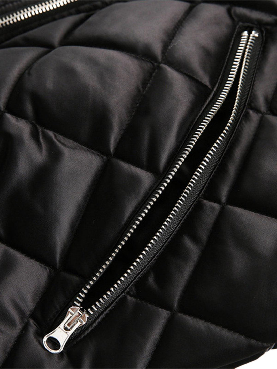 A detailed view of TALISHKO's diamond quilted jacket zipper, highlighting sleek craftsmanship.