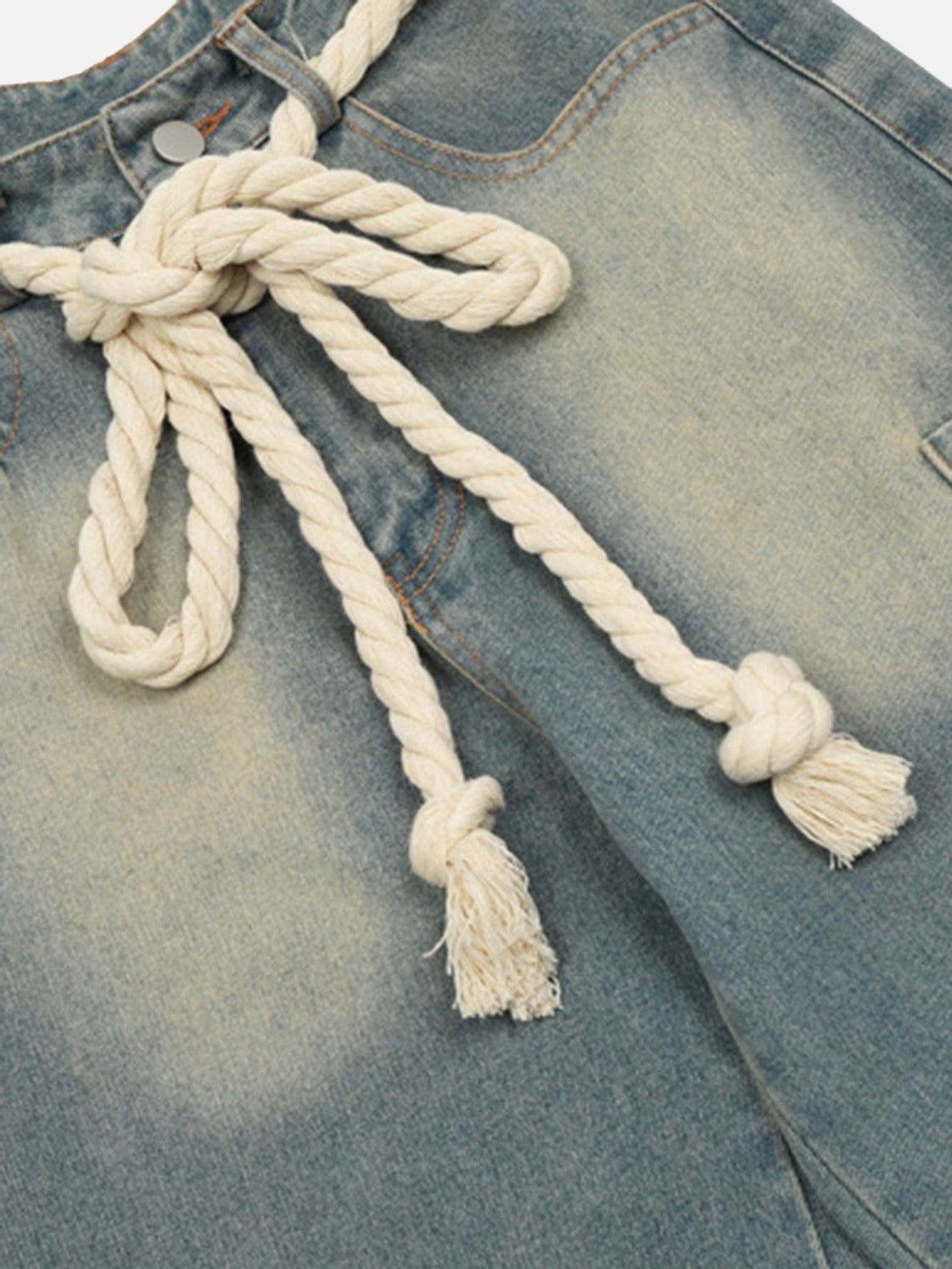 A close-up of TALISHKO loose jeans, showcasing the textured rope belt and denim fabric.
