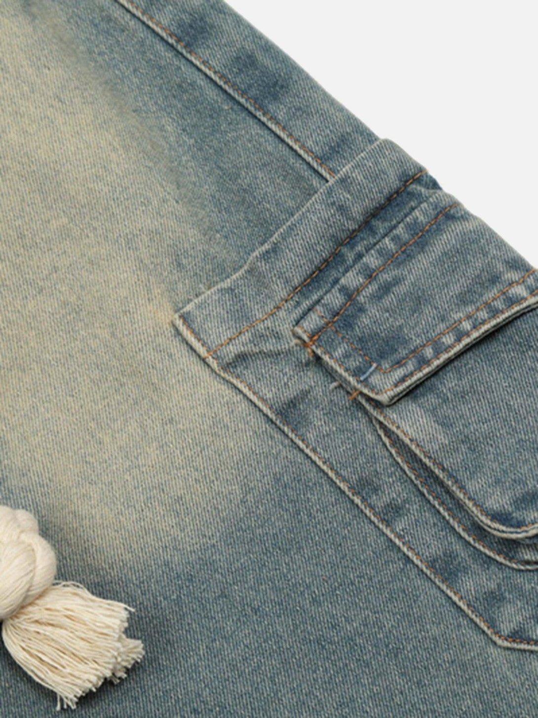 A detailed view of TALISHKO jeans pocket and denim texture, featuring a rope belt accent.
