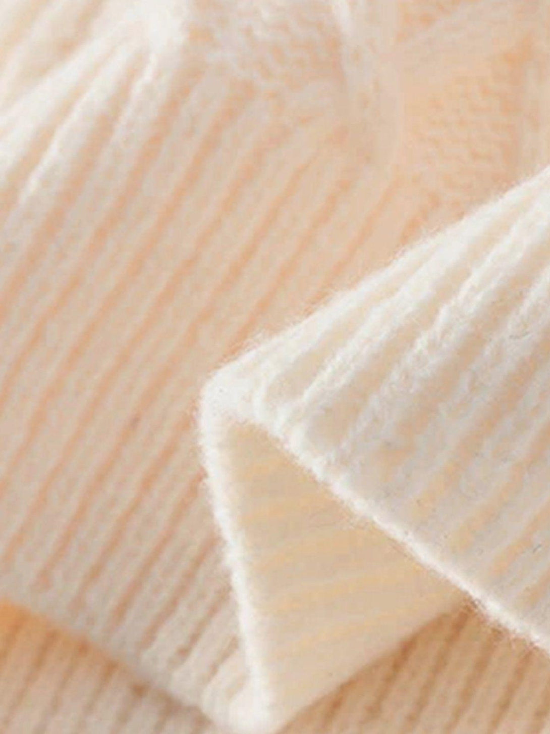 Intricate look at the soft texture of TALISHKO's Personality Twist Knit Sweater fabric.