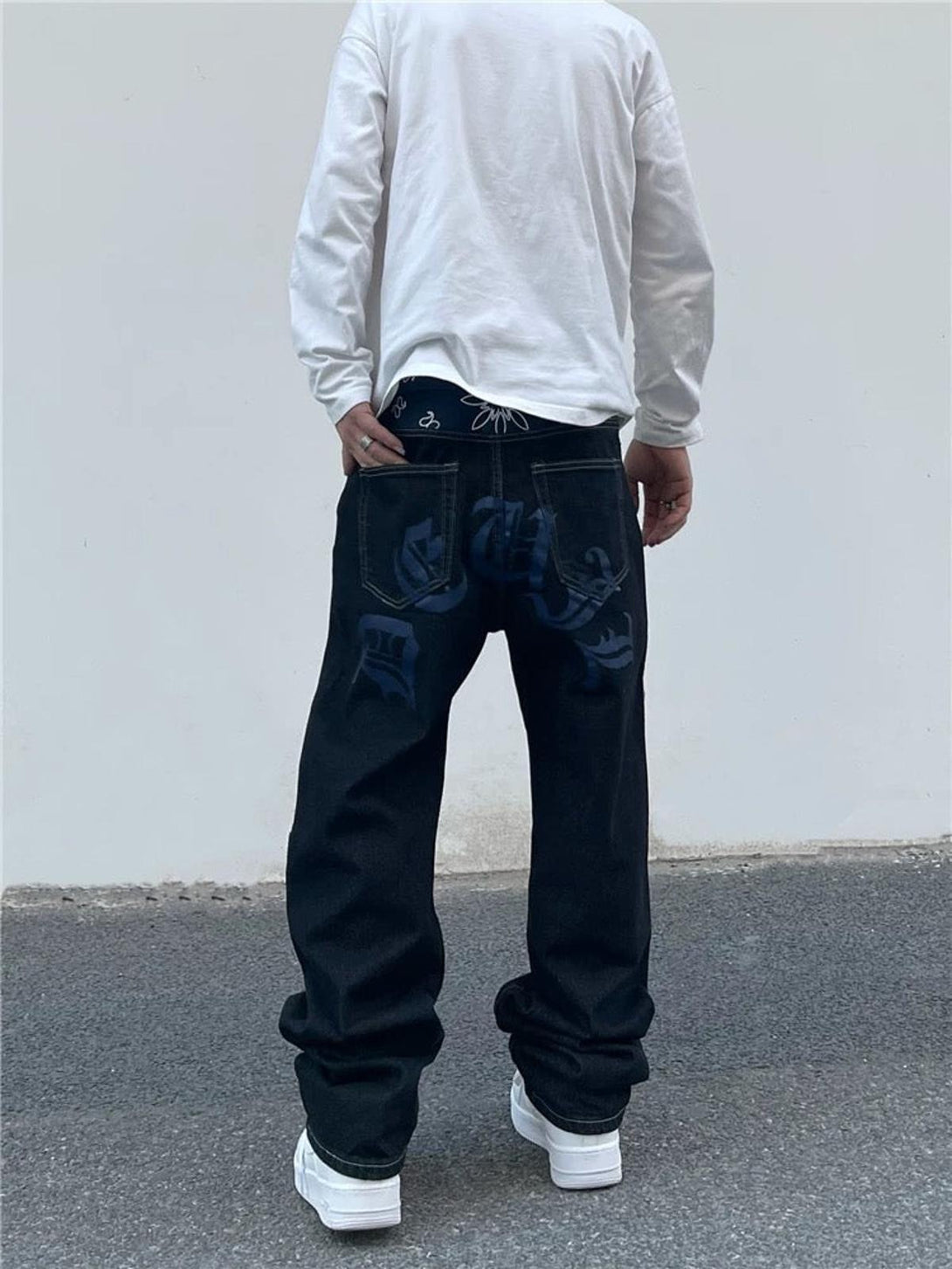 Back view of TALISHKO straight jeans featuring blue graphics and a patterned waistband.