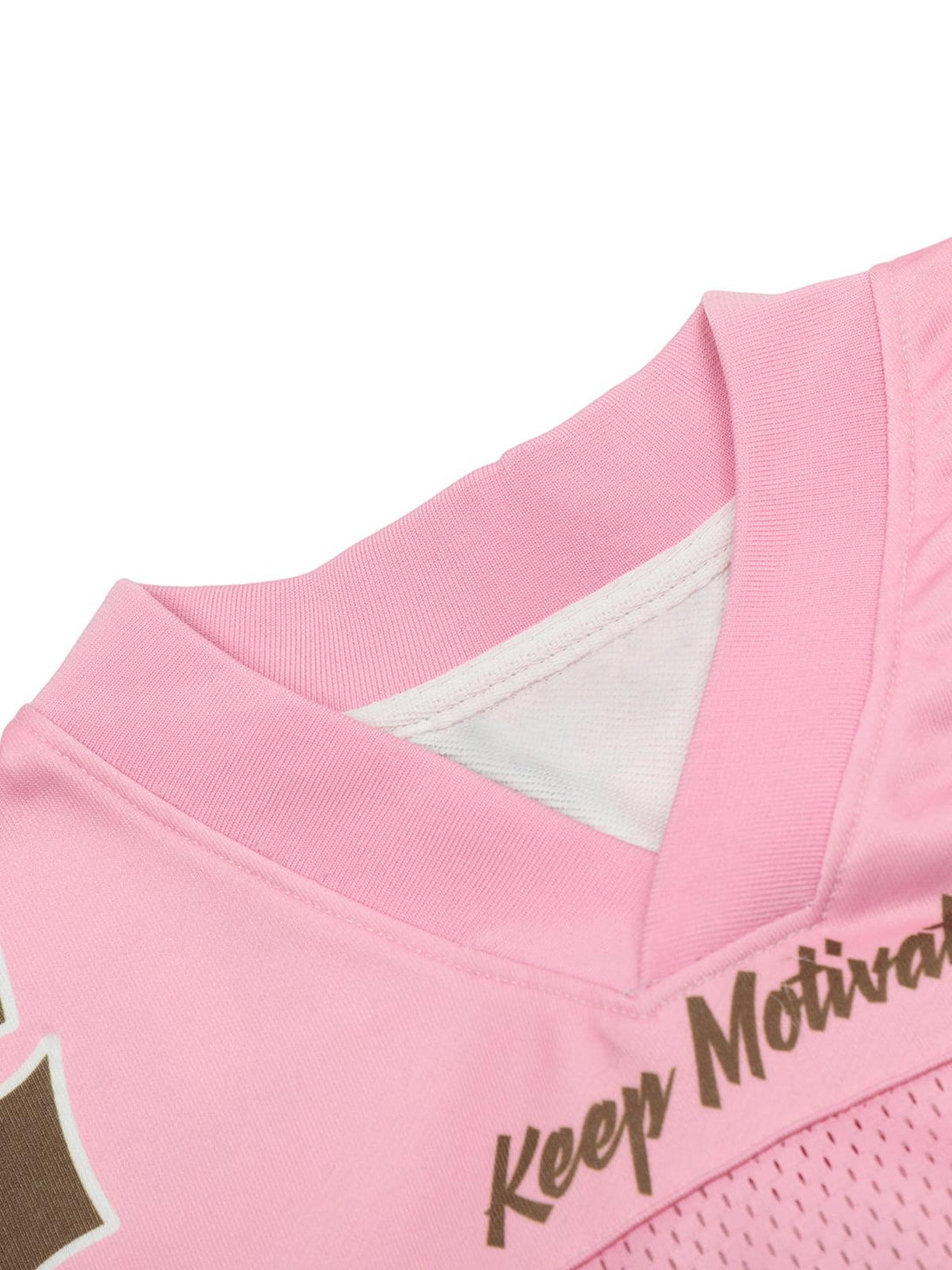 "Detailed view of TALISHKO pink jersey T-shirt neckline with motivational text accent."
