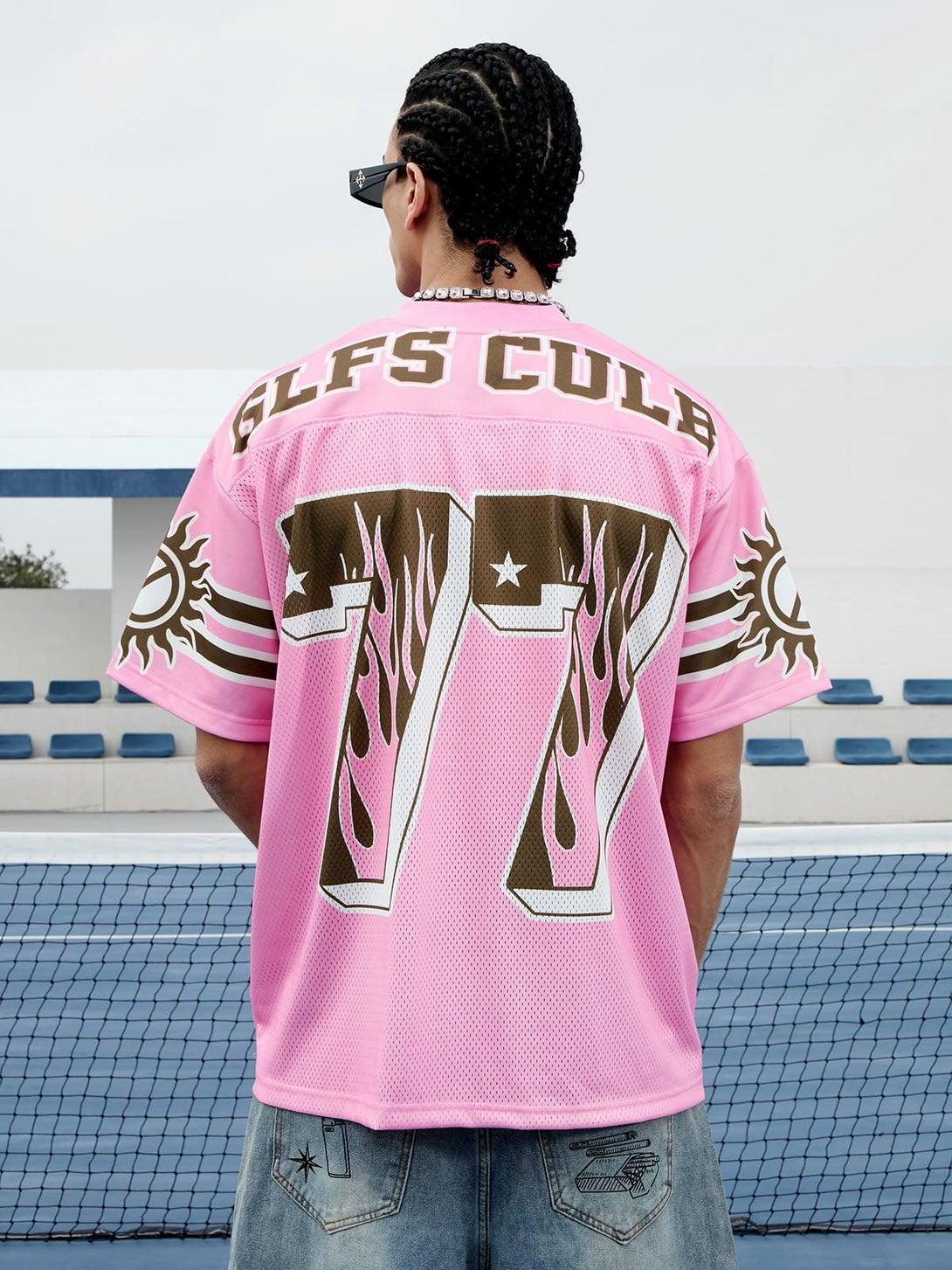 Back view of TALISHKO pink jersey T-shirt with flame graphics and "77" design, styled casually.