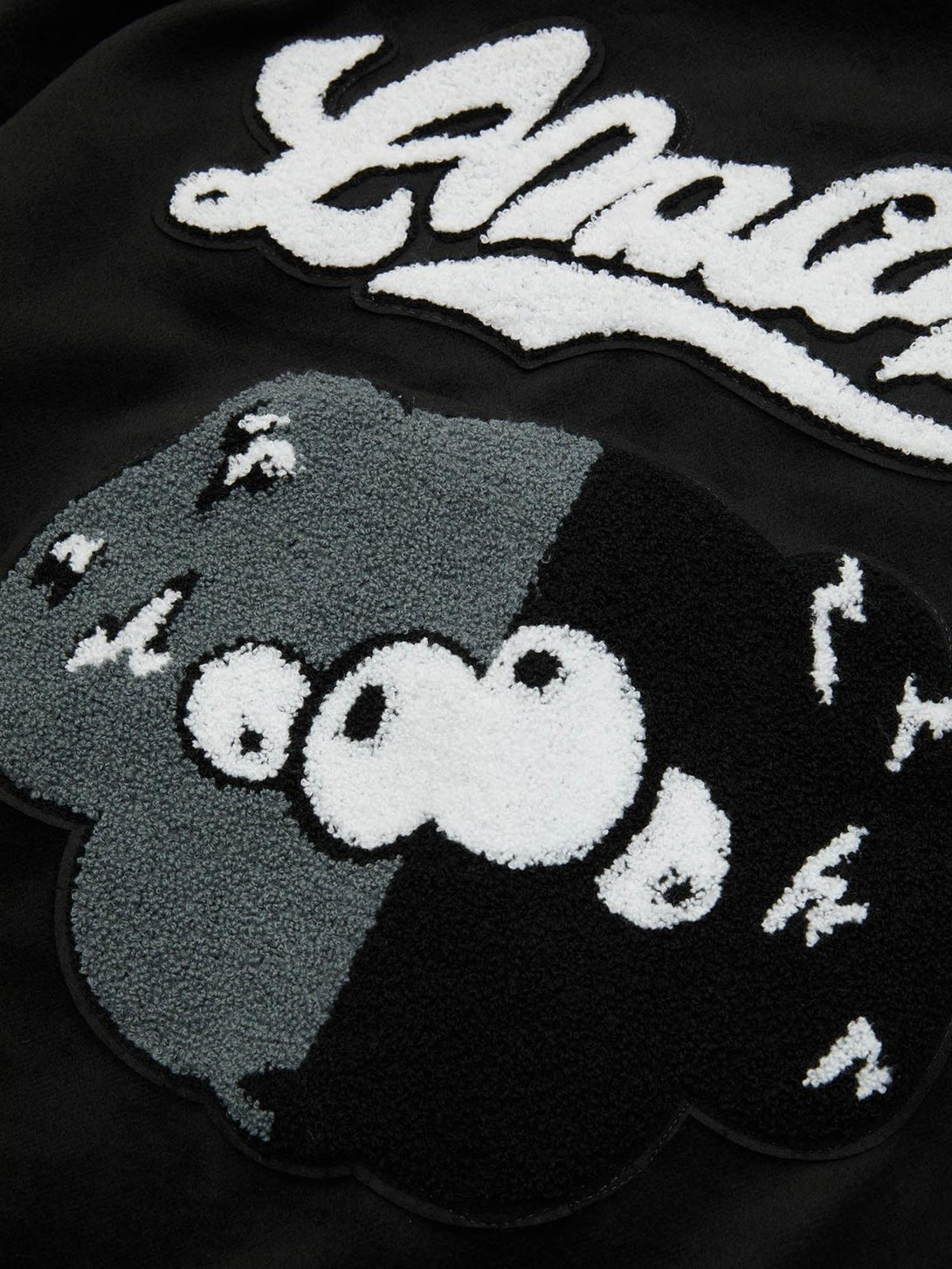 A tight crop highlighting TALISHKO's embroidered patchwork on a hip hop baseball jersey.