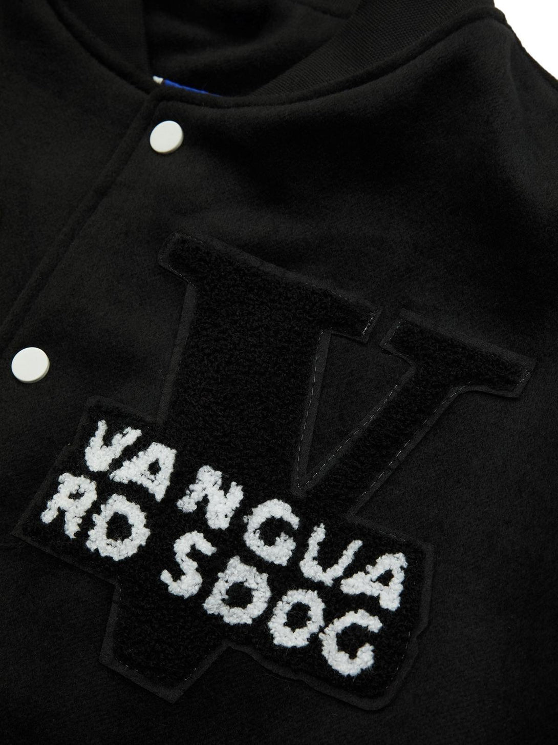 A detailed look at TALISHKO's embroidered patch on a black hip hop baseball jersey.