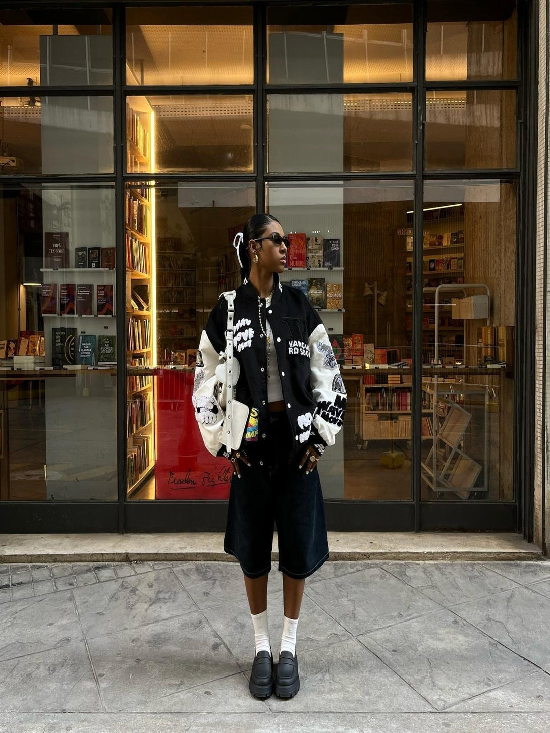 Urban streetwear style with TALISHKO varsity jacket, showcasing bold patches and hip hop vibe.