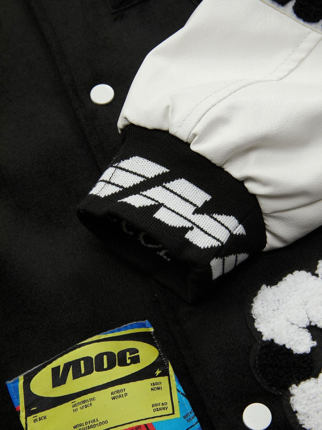 A detailed view of TALISHKO's varsity jacket sleeve, highlighting its bold embroidery and patchwork.