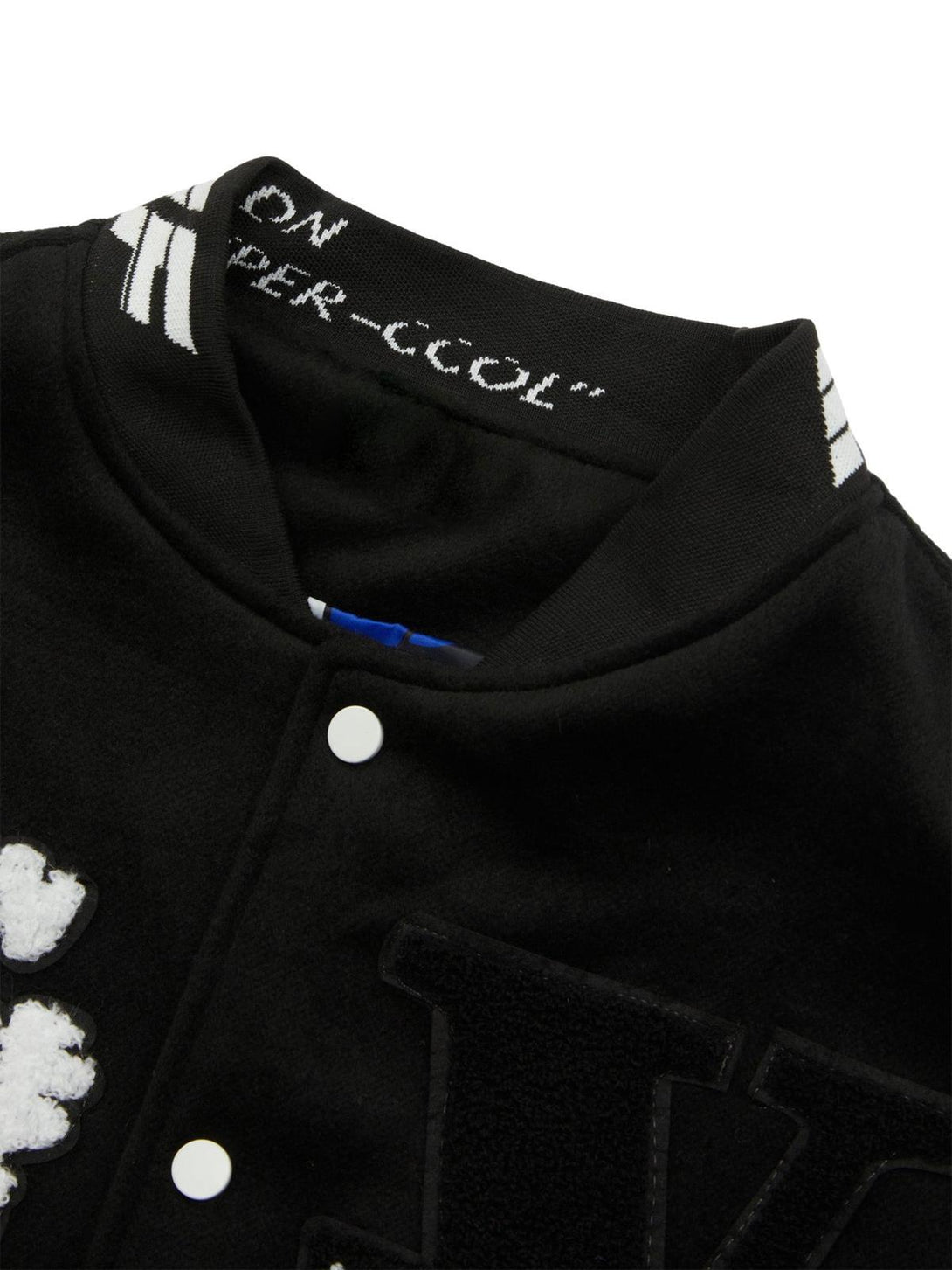 Focusing on the collar and patch details of the TALISHKO black varsity jacket.