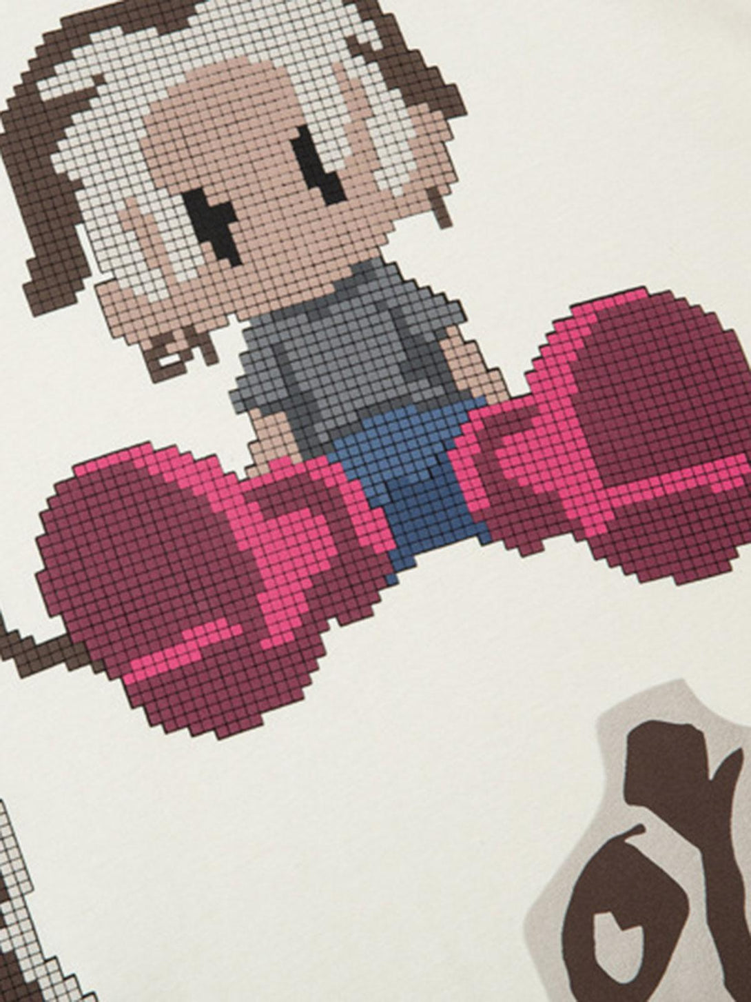 Detailed view of pixel art design on a TALISHKO T-shirt, highlighting playful cartoon graphics.