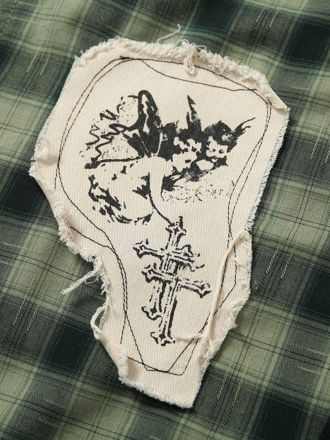 A detailed view of TALISHKO's plaid shirt applique, showcasing intricate stitching and design.